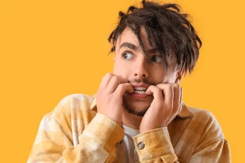 Young man having panic attack on yellow background, closeup Stock Photos