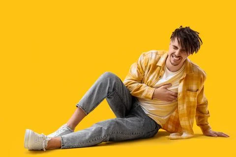 Young man having panic attack on yellow background Stock Photos