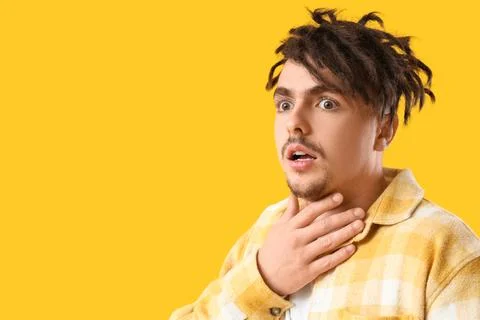Young man having panic attack on yellow background, closeup Stock Photos