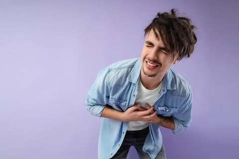 Young man having panic attack on lilac background Stock Photos