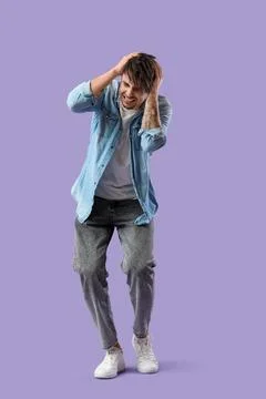 Young man having panic attack on lilac background Stock Photos