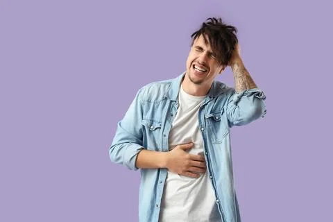 Young man having panic attack on lilac background Stock Photos