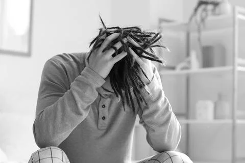 Young man having panic attack in bedroom Stock Photos