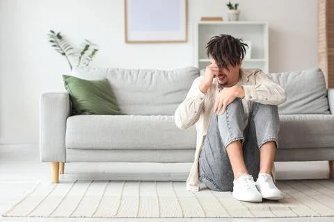 Young man having panic attack near sofa at home Stock Photos