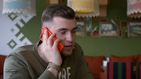 Young man having phone call conversation in the restaurant Stock Footage 74959257