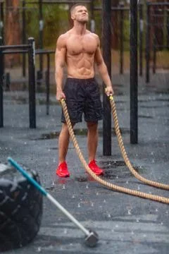 Young man having rest after rope workout in a rainy day. Stock Photos