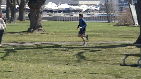 Young man having a run in the park on a sunny spring day. 4K UHD. Stock Footage 74857832