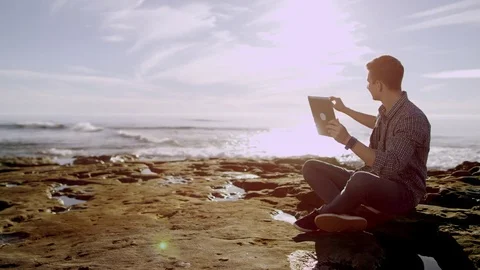 Young man is having a video conversation with his friend over his digital tablet Stock Footage 75743199