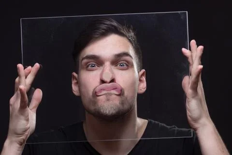 Young man head face pressed against glass Foto stock