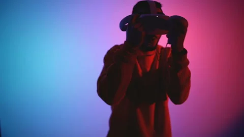 Young man with head mounted VR glasses fighting in virtual reality, doing Stock Footage 144316715