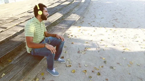 Young man with headphones listening to music and singing at park Stock Footage 59554990