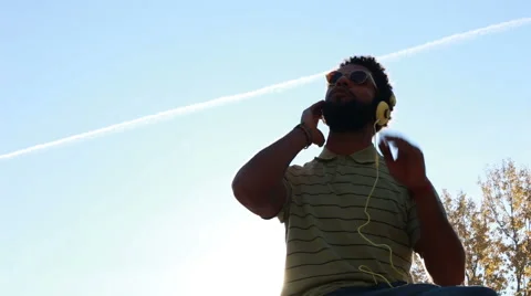 Young man with headphones listening to music at park Stock Footage 59555374
