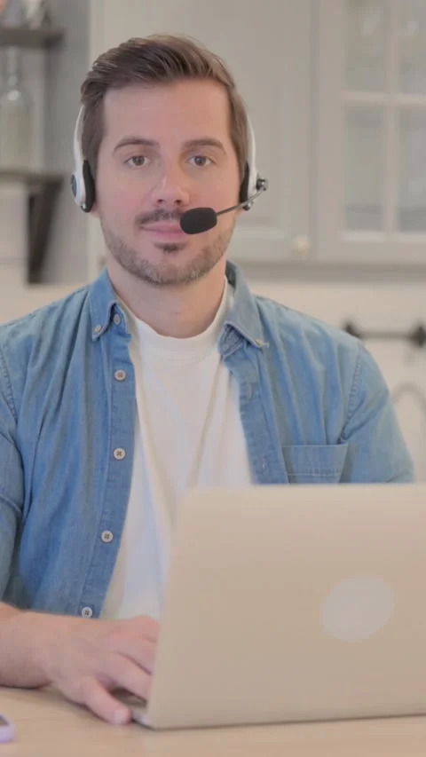 Young Man with Headset Looking toward Camera in Call Center, vertical video Video stock 328565863
