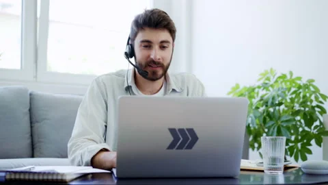 Young man with headset working from home talking during video call Stock Footage 142538648