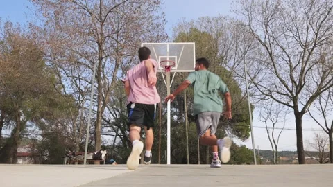 Young man helping friend to dunk basketball Stock Footage 304986346
