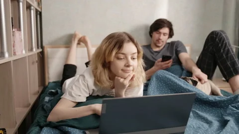 A young man helps to write a reply to a woman in a chat. They laugh together 스톡 동영상 197489685