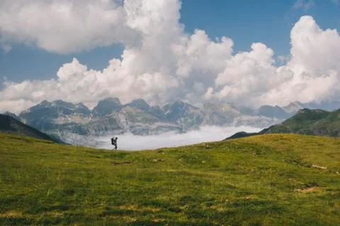 Young man hikes at Mt Aspe in the Pyrenees, while carrying his son. Stock Photos