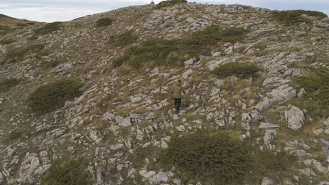 A young man hiking alone on a mountain peak, back view Stock Footage 120516432