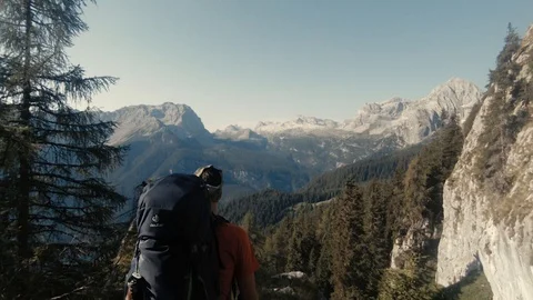 Young man hiking and looking at Dolomites mountains Stock Footage