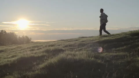 Young man hiking down mountain in outdoor nature scenery Stock Footage 64544139