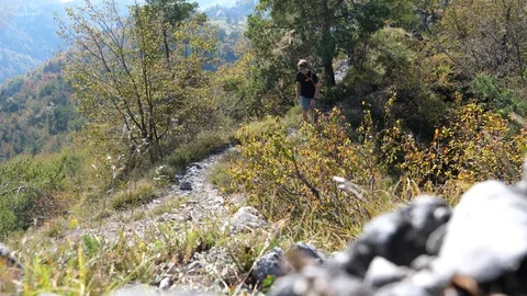 Young man hiking up a rocky path in the mountains Stock Footage 112388335