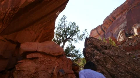 Young man hiking through a red rocked canyon in Colorado. Stock Footage 54076951
