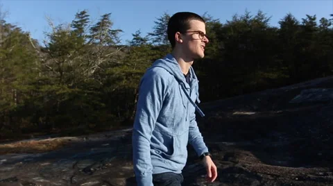 Young Man hiking to the top Stock Footage 63884556