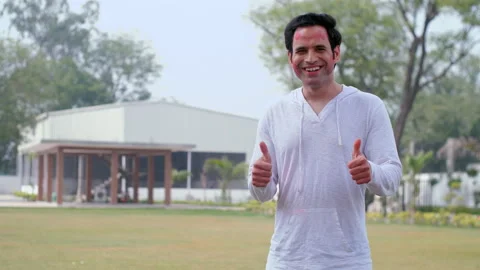A young man with his face covered in organic Gulal doing a thumbs-up gesture ... Stock Footage 171222797