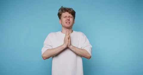 Young man with his hands pressed together in prayer reflects a moment of ho.. Stock Footage 313281107
