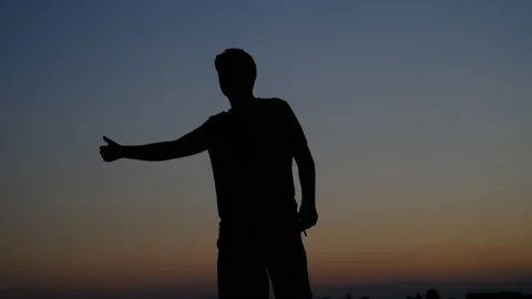 Young man hitchhiker silhouette | Stock Video | Pond5