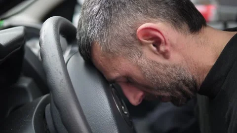 Young man hitting head on steering wheel in despair inside car Stock Footage 332418061