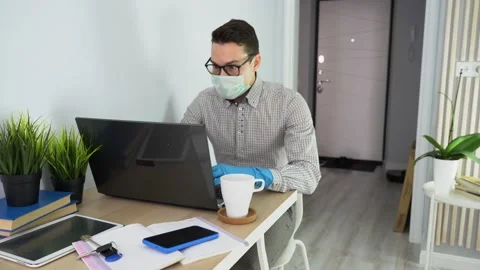 Young man hold cup, comes, goes to workplace, sit down on white chair at home. Stock Footage 131472992