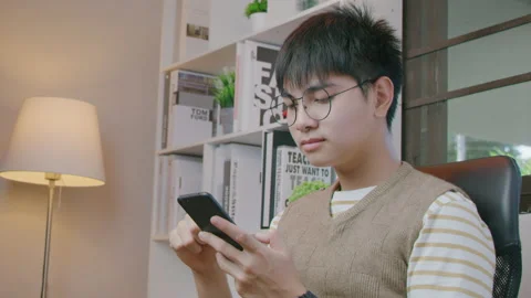 Young man holding and using smartphone in living room. Stock Footage 170036076