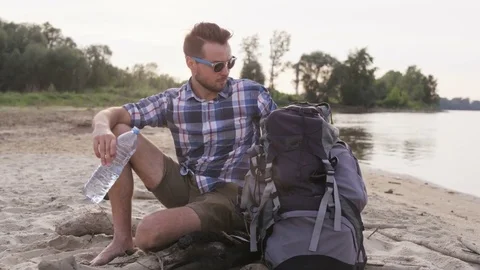 Young Man Holding a Bottle of Water and Looking Back Stock Footage 76453684