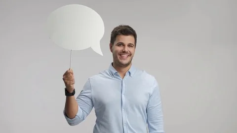 Young man holding a chat bubble and smiling Stock Footage 77993417