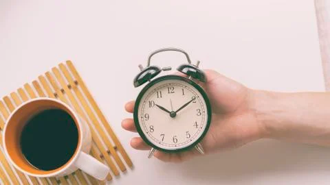 A young man holding a clock. Stock Photos