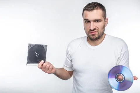 Young man holding a compact disk in one hand and a box from it in another han Stock Photos