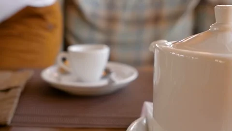 Young man holding a cup of tea in hands and drinking. A cup of tea on a table Stock Footage 108993890