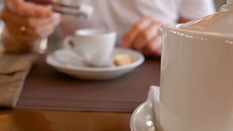 Young man holding a cup of tea in hands and drinking. A cup of tea on a table Stock Footage 108993976