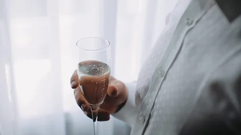 Young man is holding a glass of sparkling wine Champagne. Close up. slow motion. Stock Footage 123723347
