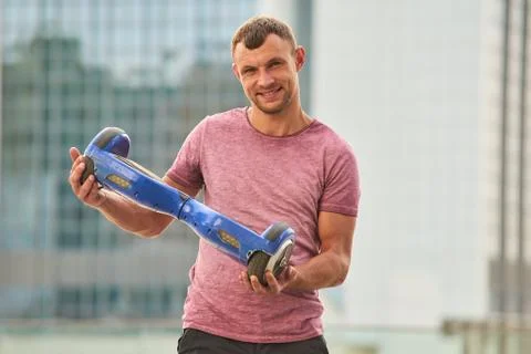 Young man holding a hoverboard. Stock Photos