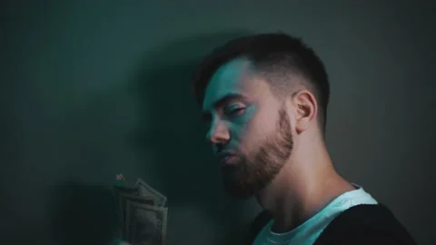 Young man holding an impressive amount of dollar bills in his hands 库存影片 147463323