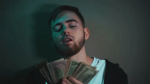 Young man holding an impressive amount of dollar bills in his hands Video stock 147463867