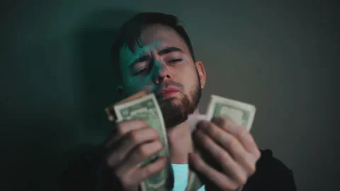 Young man holding an impressive amount of dollar bills in his hands Vidéo 147464059