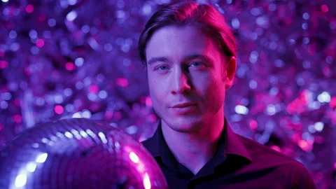 Young Man Holding Large Shiny Layer. He Is In Nightclub. Layer Spins In His Vídeos de archivo 178593746