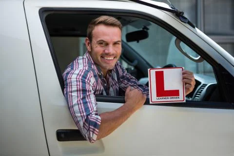 Young man holding a learner driver sign Stock Photos