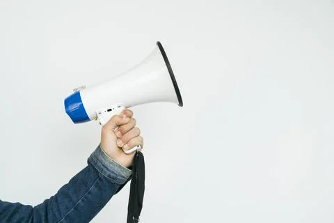 Young man holding a megaphone while posing against a white background Stock Photos