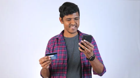 A young man holding mobile phone and another hand holding credit card plain.. Stock Footage 249700764