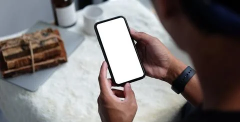 Young man holding mockup smart phone with empty screen. Close up. Stock Photos