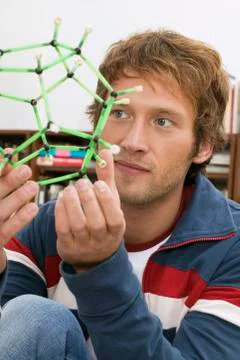 Young man holding model of molecule, close-up Stock Photos